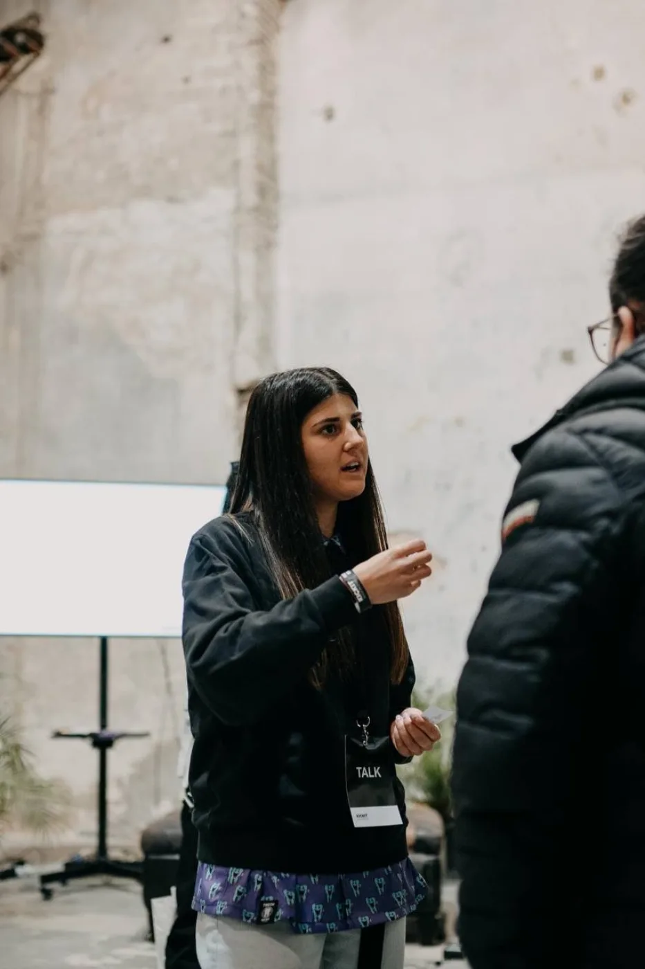 Susanna in conversazione con un partecipante dopo il talk in uno spazio industrial
